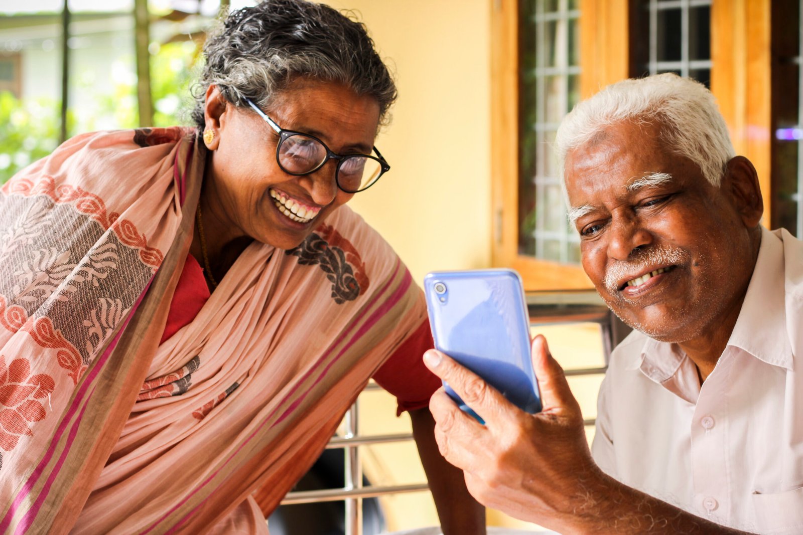 elder couple enjoying social media in mobile phone
